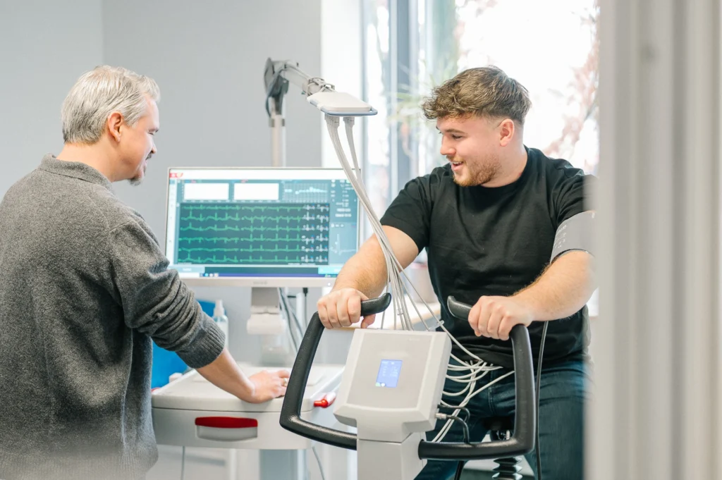 Arzt überwacht Belastungs-EKG am Fahrradergometer in der arbeitsmedizinischen Praxis der MBS GmbH