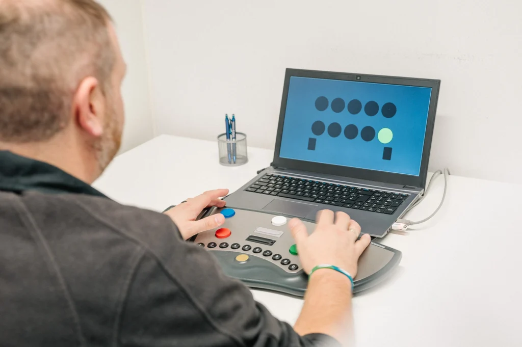 Person führt einen computergestützten Reaktionstest in der MBS-Praxis durch